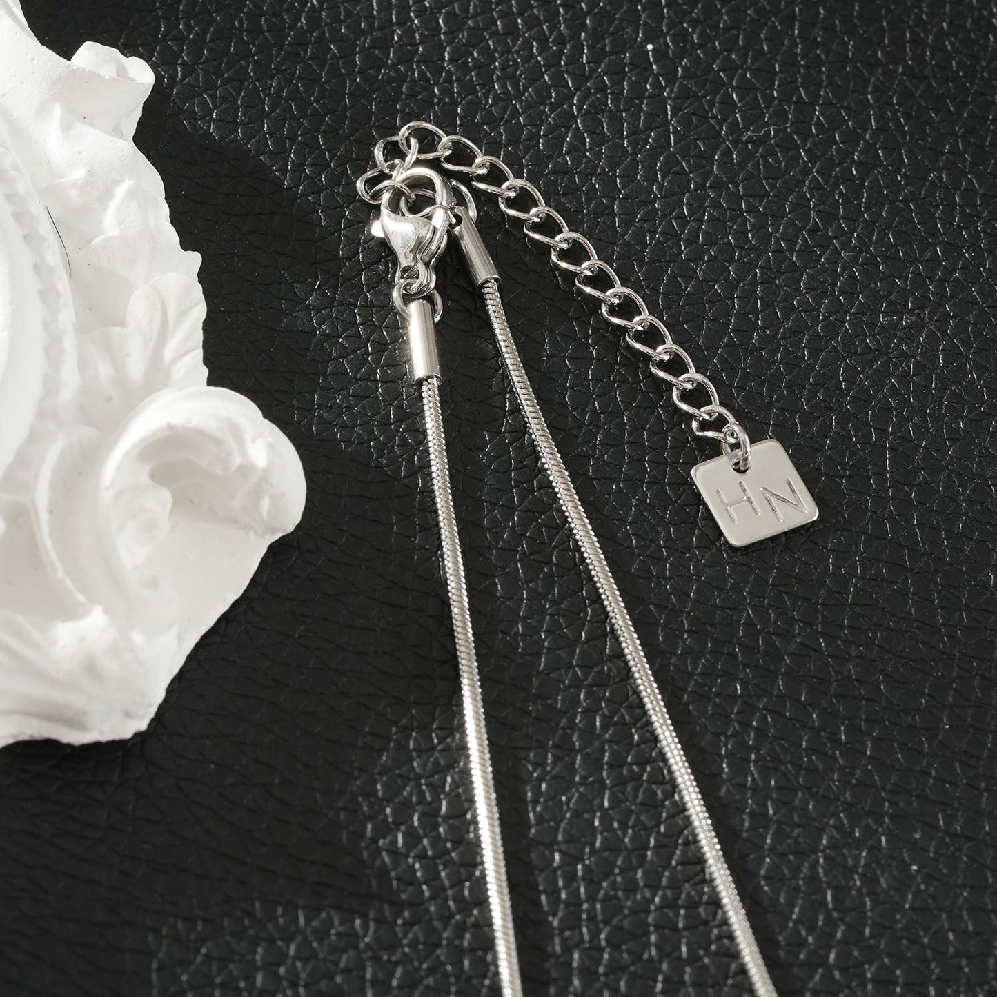 HACKNEY NINE Silver (White Gold) sculptural knot pendant necklace with intricate design and polished finish.