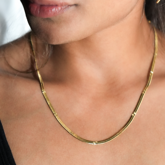 HACKNEY NINE Jewelry BAMBURG Gold star embossed snake skin textured chain necklace displayed on a model