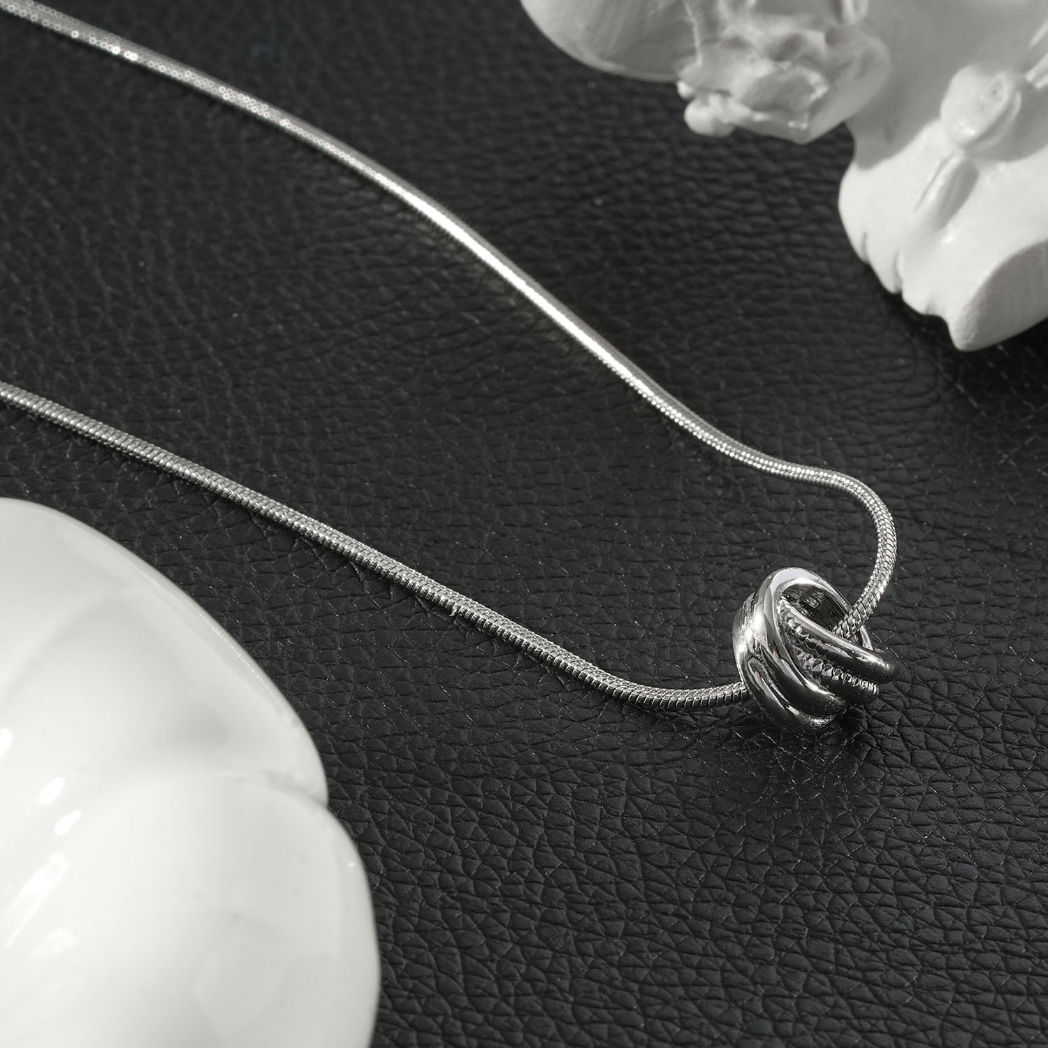 HACKNEY NINE Silver Sculptural Knot Pendant Necklace with white gold finish, featuring an intricate, elegant design.