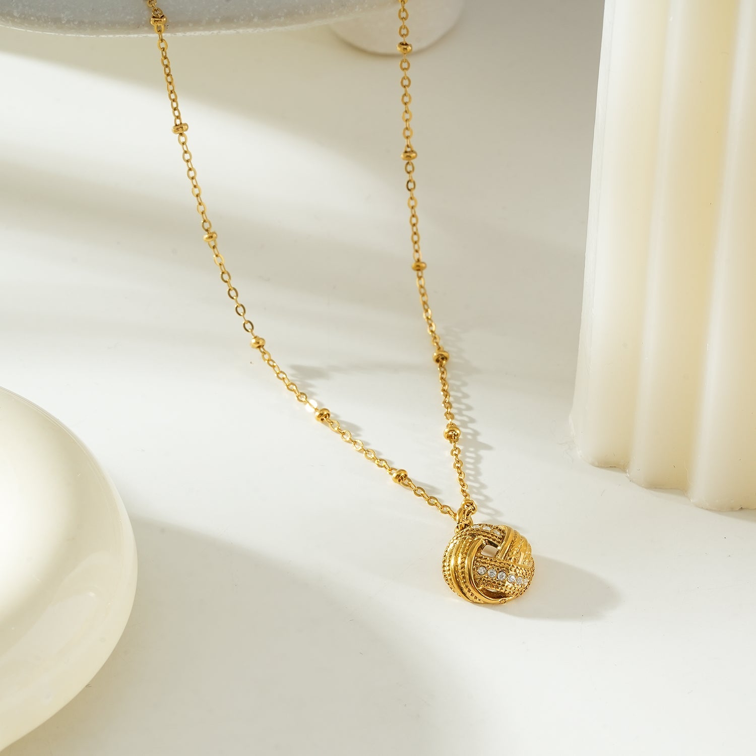 Salamasina Gold crystal interwoven knot pendant necklace by Hackney Nine Jewellery, showcasing a elegant gold necklace with sparkling crystal details.