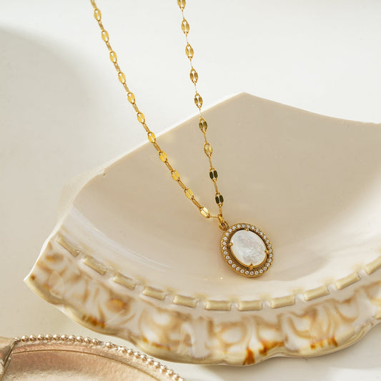 HACKNEY NINE Jewellery HAMMELA Gold pendant necklace with a pearl center and crystal halo, showcasing elegant gold jewelry design.